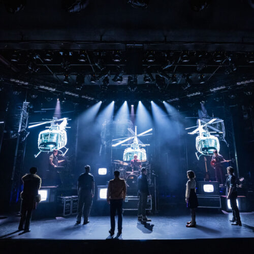 The Rolling Thunder cast on stage beneath projected helicopters in New York